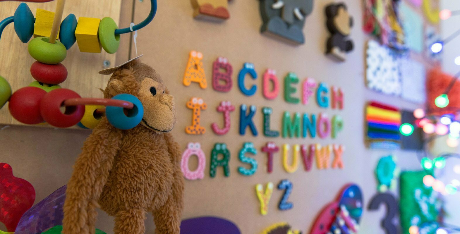 background image showing a fun board with letters and toys